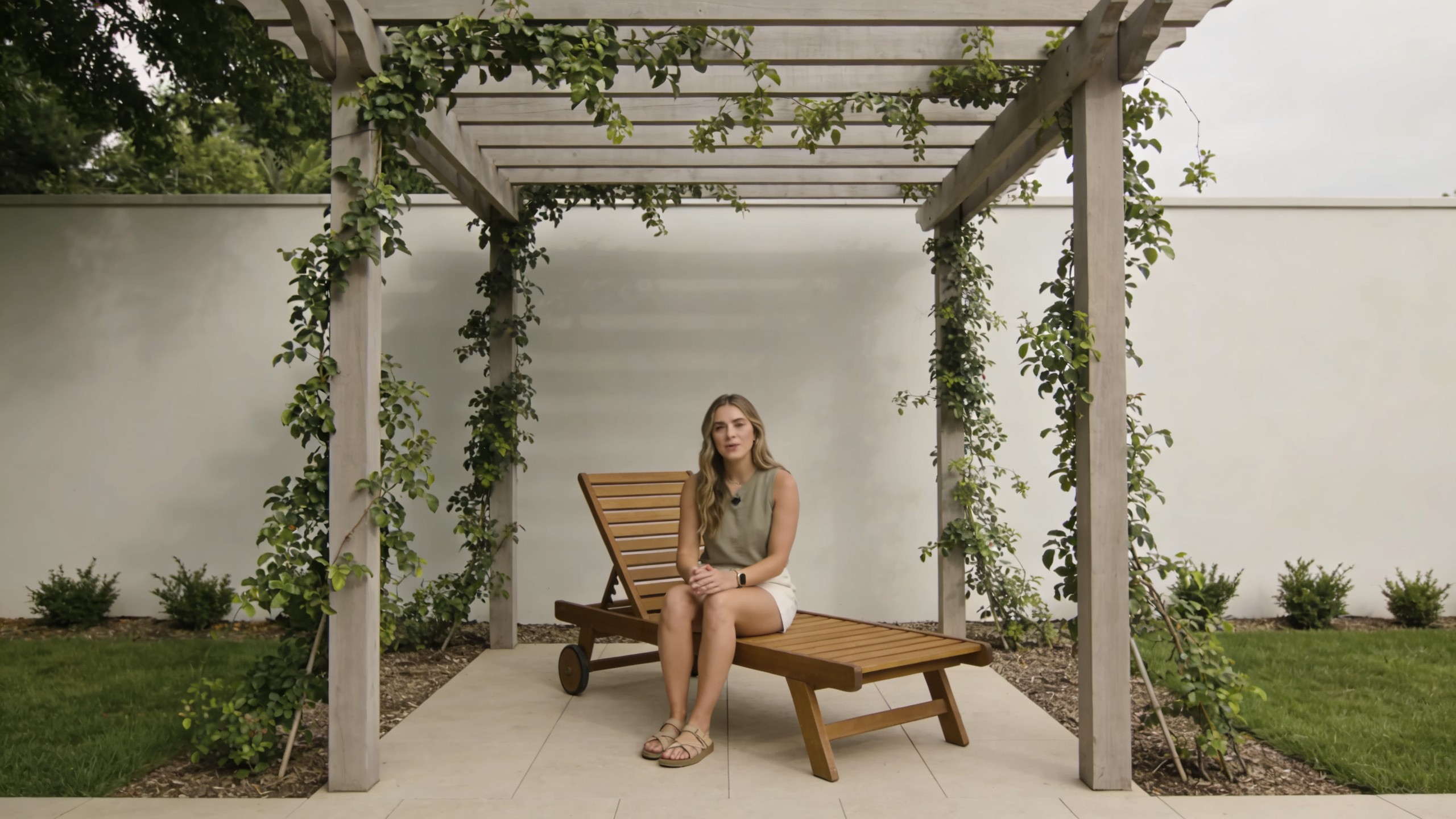 femme assise sur transat bois sous pergola jardin