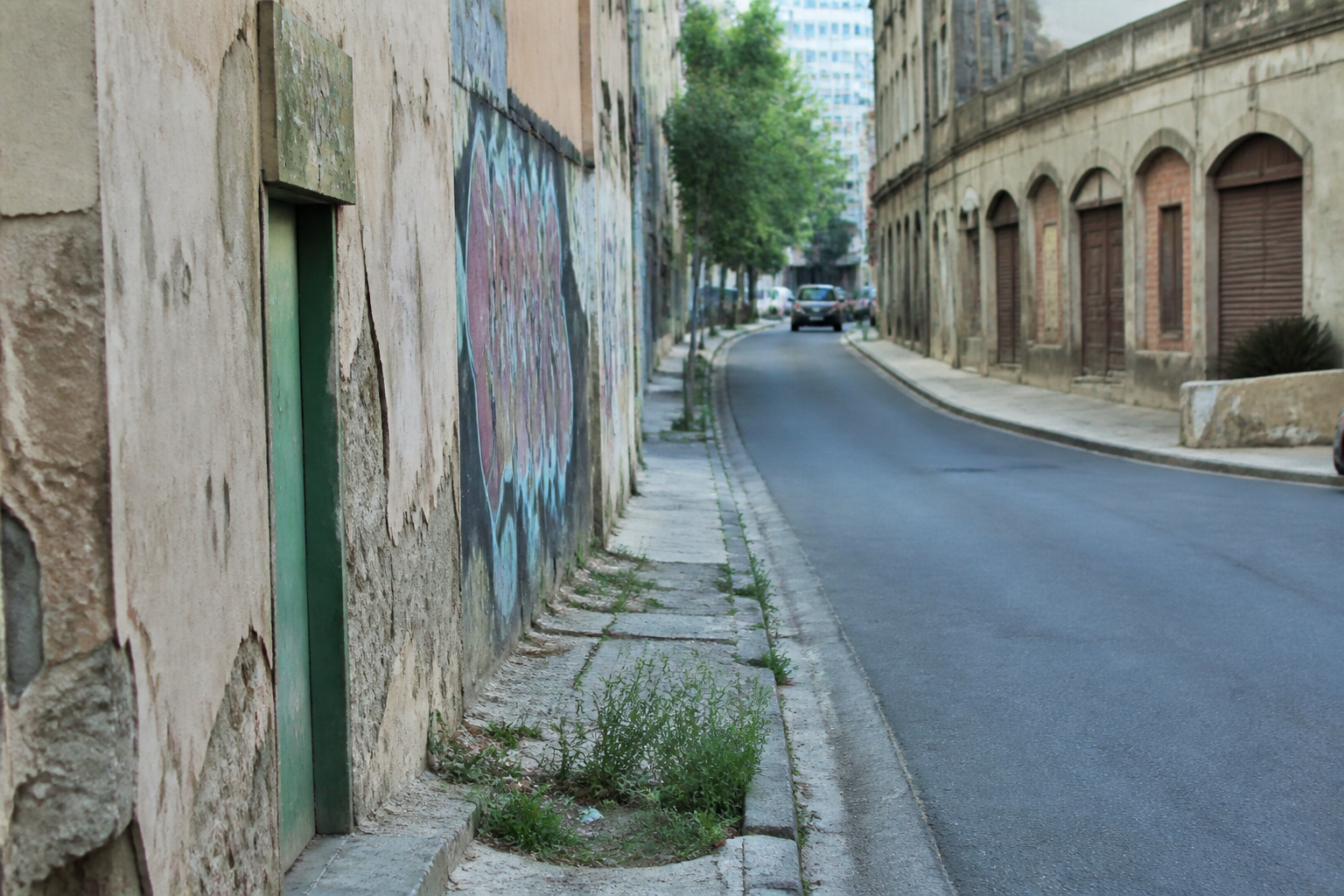 Rue urbaine desertre avec batiments delabres et graffitis visibles