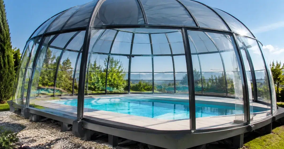 Dôme transparent suréleve au-dessus piscine bleu, structure rigide imposante