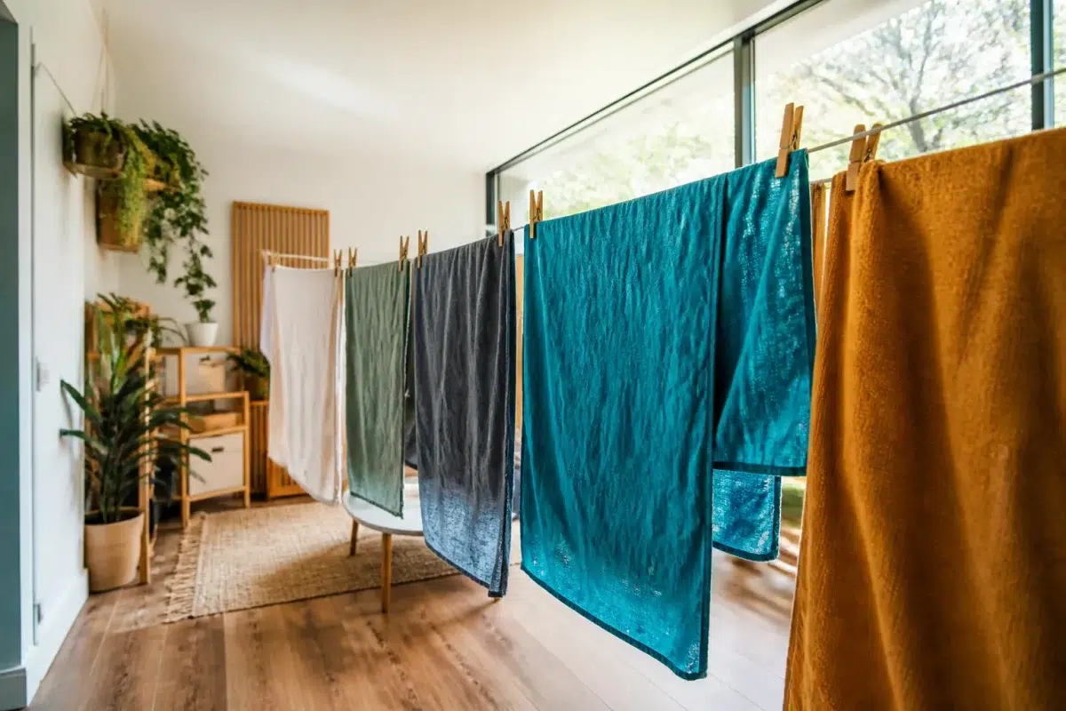 Linge humide suspendu dans piece bien organisee et ventilee