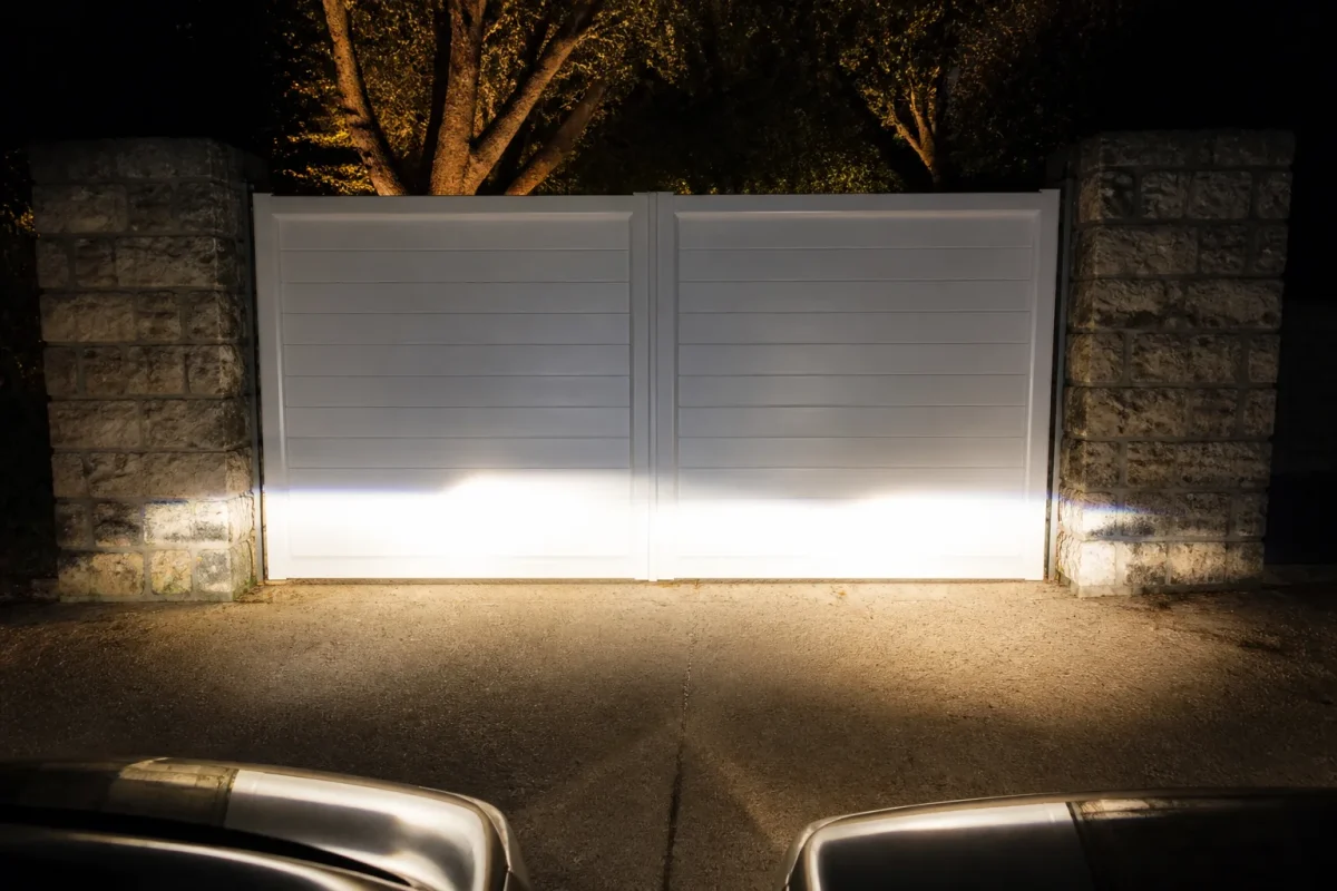 Portail blanc reflechissant brille sous phares autos