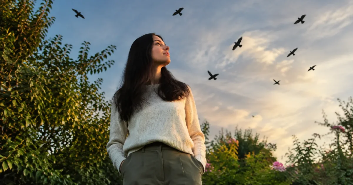 Femme debout au jardin silhouettes sombres dans le ciel