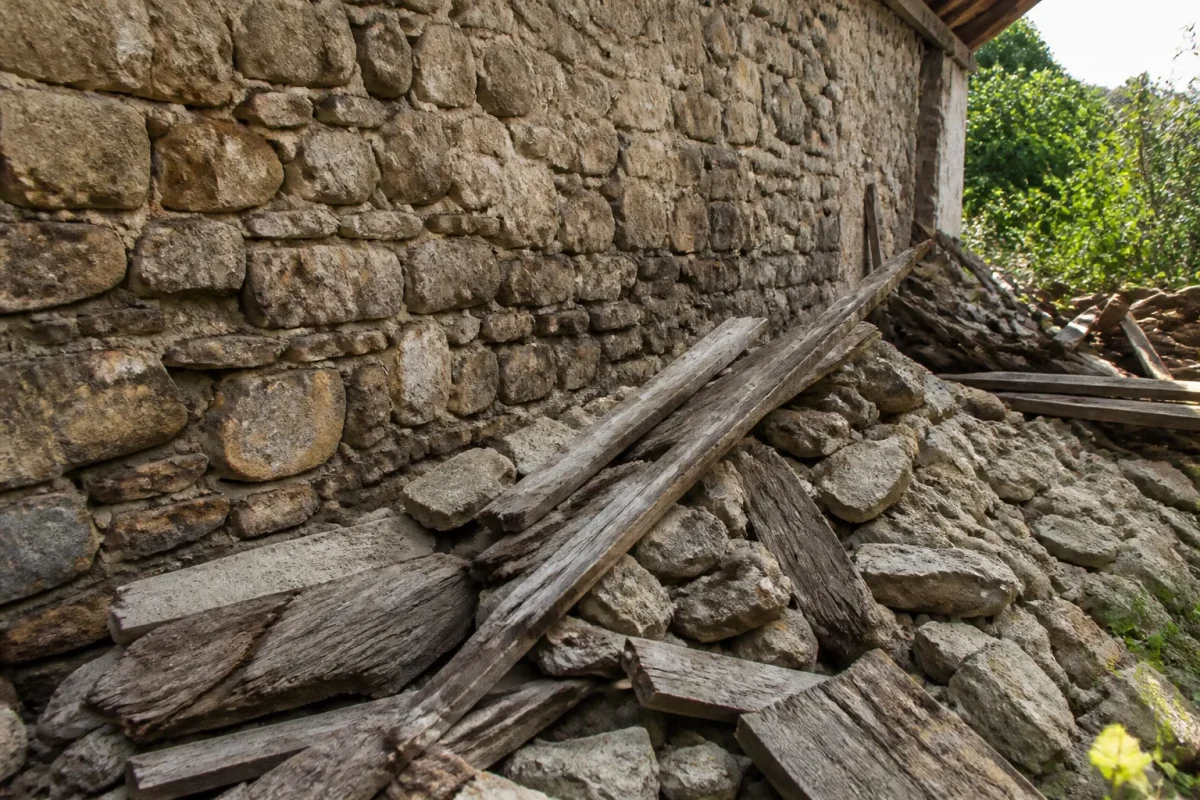 Vieux mur en pierre couvert de gravats et planches